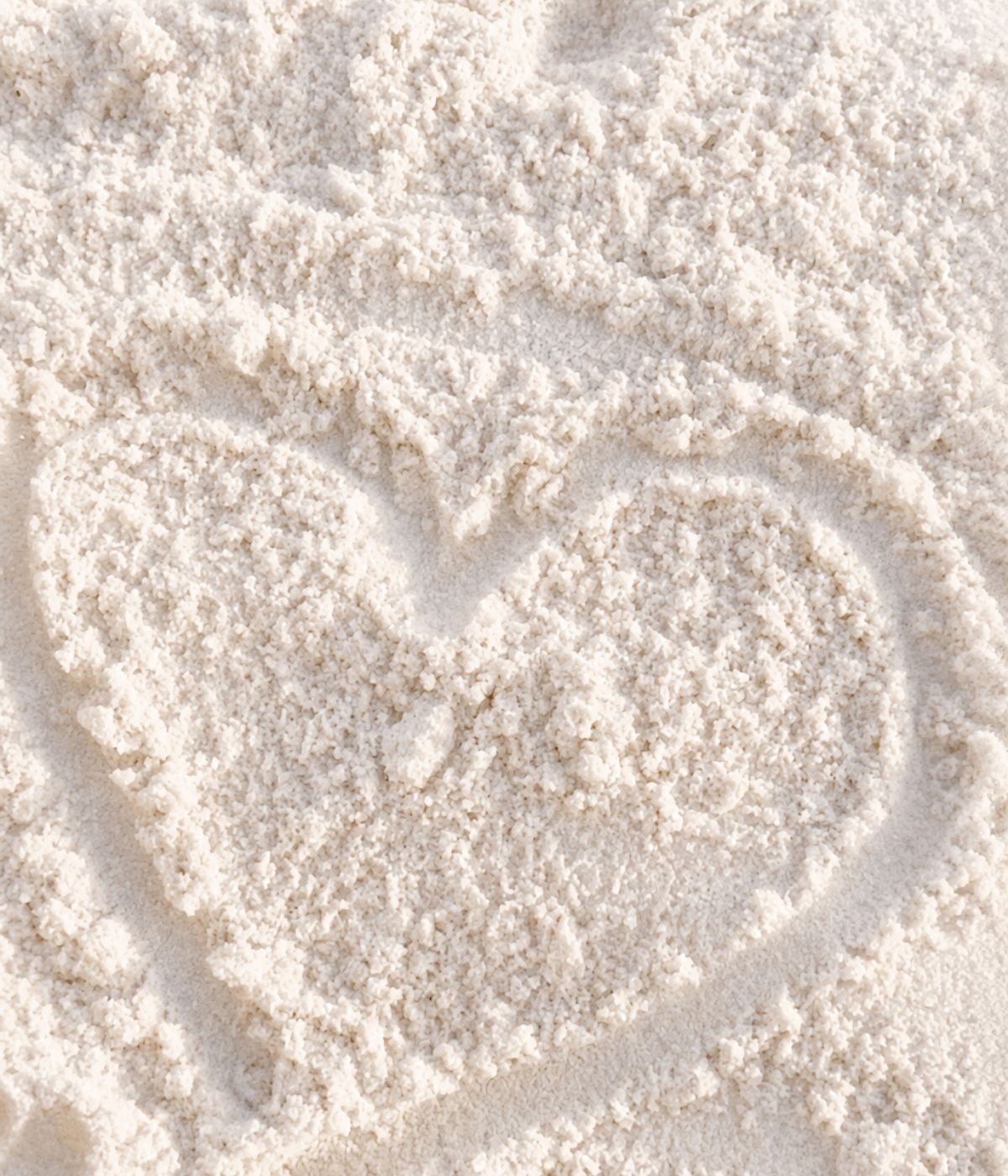 A heart drawn in soft white sand